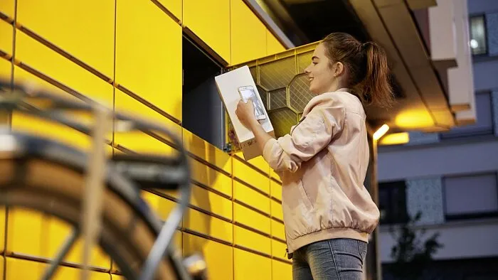 O persoană predă un colet la un locker